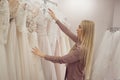 Beautiful girl chooses her wedding dress. Young woman entrepreneur. Portrait in Bridal salon Royalty Free Stock Photo