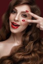 Beautiful girl with a classic make up, curls hair and red nails. Manicure design. Beauty face. Royalty Free Stock Photo