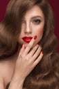 Beautiful girl with a classic makeup, curls hair and red nails. Manicure design. Beauty face. Royalty Free Stock Photo