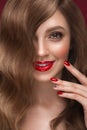 Beautiful girl with a classic makeup, curls hair and red nails. Manicure design. Beauty face. Royalty Free Stock Photo