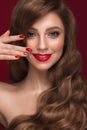 Beautiful girl with a classic makeup, curls hair and red nails. Manicure design. Beauty face.