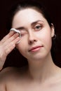 Beautiful girl cleans her face from makeup. Black background Royalty Free Stock Photo