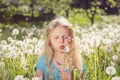 Child blowing white dandelion flowers