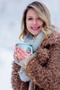 Girl in coat with cup of drink in a snow forest
