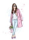 Beautiful girl in a coat and pants with a bouquet of tulips. Fashion and style, clothes and accessories. Flowers and spring.