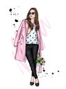 Beautiful girl in a coat and pants with a bouquet of tulips. Fashion and style, clothes and accessories. Flowers and spring. Royalty Free Stock Photo