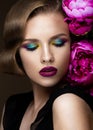 Beautiful girl with colorful make-up, flowers, retro hairstyle. beauty face. Royalty Free Stock Photo