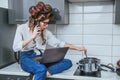 Beautiful girl is cooking and  talking on a smartphone. Royalty Free Stock Photo