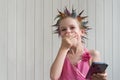 The beautiful girl covered her mouth with her hand in surprise. A child in an evening dress with a beautiful hairstyle looks at Royalty Free Stock Photo