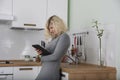 Beautiful girl with curly hair is absorbedly watching something in tablet Royalty Free Stock Photo