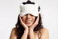 Beautiful girl with curly hair in a cheerful white and fluffy sleep mask