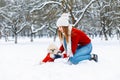 Beautiful girl with a cute dog walking in a winter park.