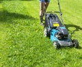 Beautiful girl cuts the lawn. Mowing lawns. Lawn mower on green grass. mower grass equipment. mowing gardener care work tool Royalty Free Stock Photo