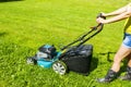 Beautiful girl cuts the lawn, Mowing lawns, Lawn mower on green grass, mower grass equipment, mowing gardener care work tool Royalty Free Stock Photo