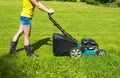 Beautiful girl cuts the lawn, Mowing lawns, Lawn mower on green grass, mower grass equipment, mowing gardener care work tool Royalty Free Stock Photo