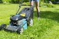 Beautiful girl cuts the lawn Mowing lawns Lawn mower on green grass mower grass equipment mowing gardener care work tool close up Royalty Free Stock Photo