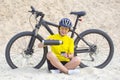 Beautiful girl cyclist pours tea from a thermos on the background of a Bicycle in the sand. Sports and recreation. Hobbies and