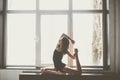 Beautiful girl dancer with long flowing hair in black clothes, swimsuit,in a beautiful beautiful pose on the big window Daylight, Royalty Free Stock Photo