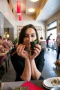 Beautiful girl with dark hair, dressed in black is holding chopsticks and temaki sushi Royalty Free Stock Photo