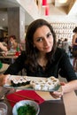 Beautiful girl with dark hair, dressed in black is holding a plate full of sushi Royalty Free Stock Photo