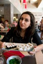 Beautiful girl with dark hair, dressed in black is holding a plate full of sushi Royalty Free Stock Photo