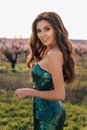 beautiful girl with dark hair in elegant dress posing in blooming peach garden Royalty Free Stock Photo