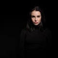 Beautiful girl with dark hair posing over black background. Young pretty woman Royalty Free Stock Photo