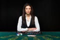 The beautiful girl, dealer, behind a table for poker Royalty Free Stock Photo