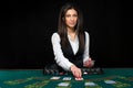 The beautiful girl, dealer, behind a table for poker Royalty Free Stock Photo