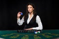 The beautiful girl, dealer, behind a table for poker Royalty Free Stock Photo