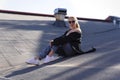 Beautiful girl decided to relax on the roof of the house.