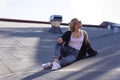 Beautiful girl decided to relax on the roof of the house. Dressed in blue jeans with a T-shirt and sweater