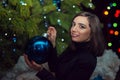 A beautiful girl decorates a Christmas tree on New Years Eve. Royalty Free Stock Photo