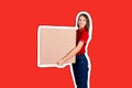 Beautiful girl is delivering a huge parcel to a customer. Smiling woman in work clothes is holding a box Magazine collage style Royalty Free Stock Photo