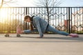 beautiful girl in denim and pink sneakers does the splits on a penny board, a longboard. International Skateboarding Day.