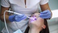 Woman at dentist clinic gets dental treatment to fill a cavity in a tooth. Dental restoration and material