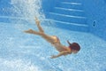 Beautiful girl dives and swims underwater in pool