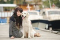 Beautiful girl with a dog on the pier in the summer Royalty Free Stock Photo