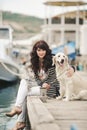 Beautiful girl with a dog on the waterfront Royalty Free Stock Photo