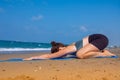 A beautiful girl is doing yoga on the beach near the sea Royalty Free Stock Photo