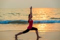 Beautiful girl doing yoga near the ocean
