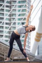 beautiful girl doing yoga on street .young sport woman stretching arm and leg in urban city outdoors . person . female fitness Royalty Free Stock Photo