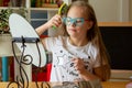 A beautiful girl with Down syndrome combs in front of a mirror