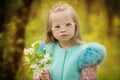 Beautiful girl with down syndrome holding spring flowers Royalty Free Stock Photo