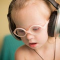 Beautiful girl with Down syndrome is listening to music on headphones Royalty Free Stock Photo