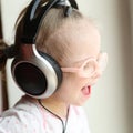 beautiful girl with Down syndrome is listening to music on headphones Royalty Free Stock Photo