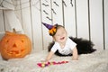 Beautiful girl with Down syndrome thoughtfully keeps finger in the mouth near the big pumpkin Royalty Free Stock Photo