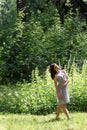 Beautiful girl in dress with long hair standing in woods Royalty Free Stock Photo