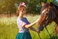 Beautiful girl in a dress standing with a horse in nature