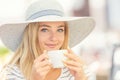 Beautiful girl drinking coffee in a cafe terrace. Summer portrait young woman